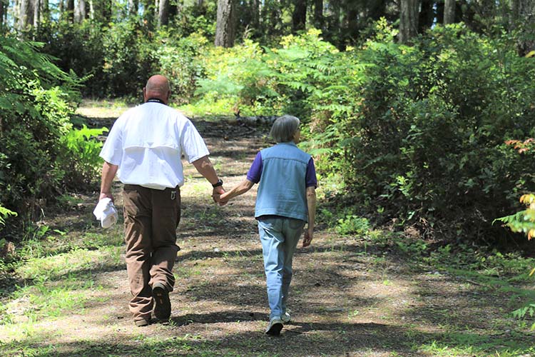 Mark and Beth Bister walking while holding hands to view the wildlife on their farm.