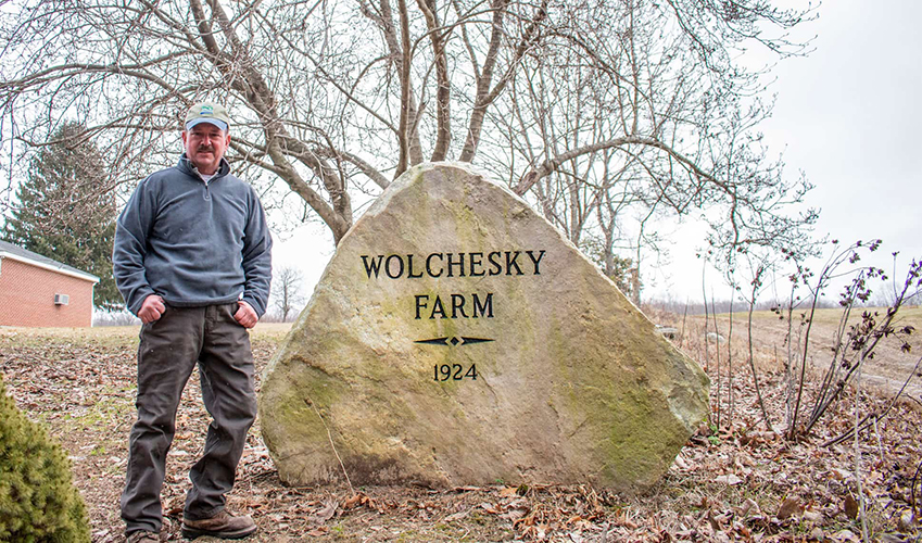  John Wolchesky, Jr. standing in front of his family rock for Wolchesky Farm.