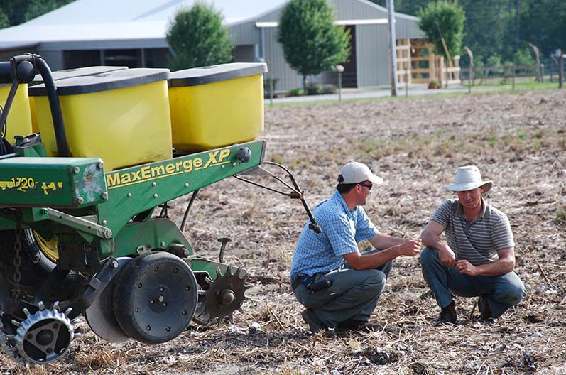 Joey Koptis (left) discusses soil health with Michael Mullek (right), a row crop farmer in Alabama