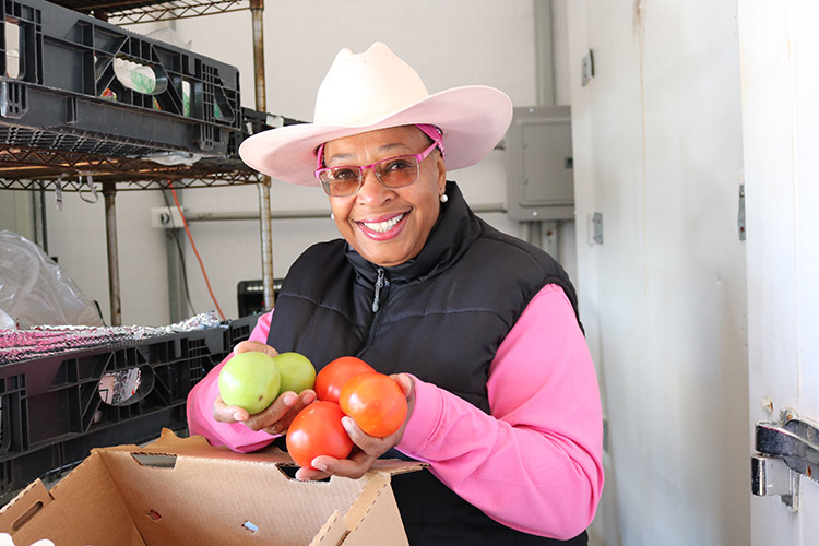 Dr. Cindy Ayers-Elliott holding produce.