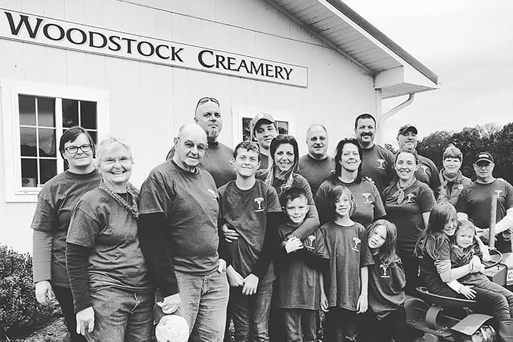 Family photo of the Young family standing in front of the Woodstock Creamery Farm Store at Valleyside Farm.