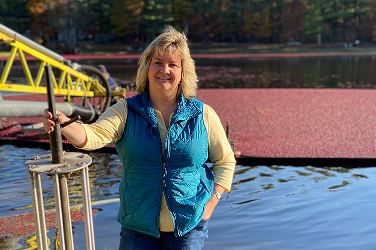 Dawn Allen stands in front of a bog with ripe cranberries ready for harvest. Photo Credit: Dawn Allen, Freetown Farm LLC