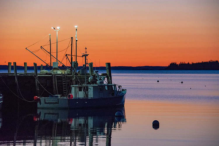 A fishing boat off the coast of Maine at sunrise. 