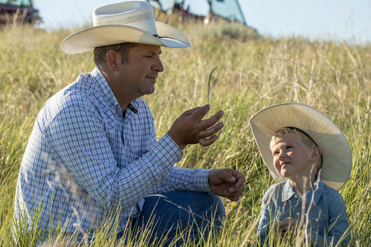 Britton Blair teaches his son Jack how to identify different grass species on their South Dakota ranch.