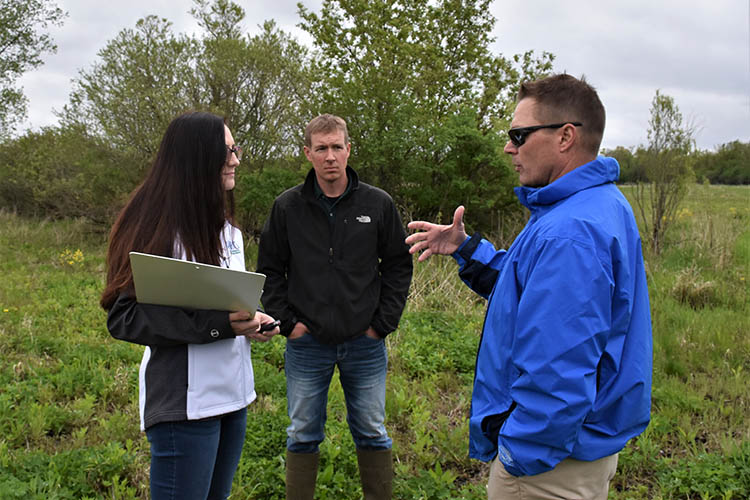 (L to R) Tivoli Gough, NRCS state public affairs specialist, Caleb Zahn , and TJ Rogers discuss the 60-acre easement. Photo taken in 2017.