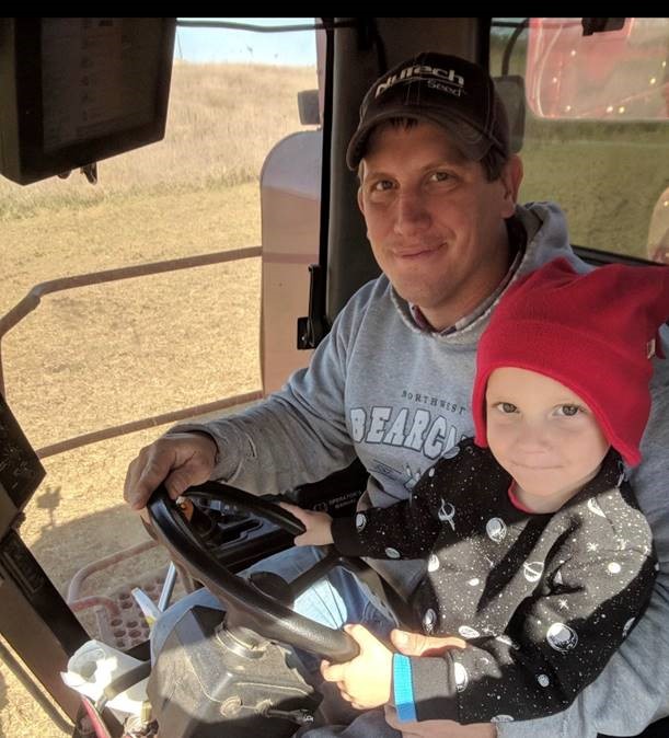 Brett Gilland and son in tractor cabin