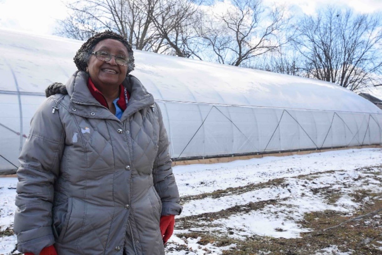 Person in front of greenhouse