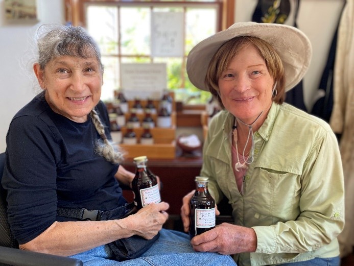 two people sitting while holding bottles