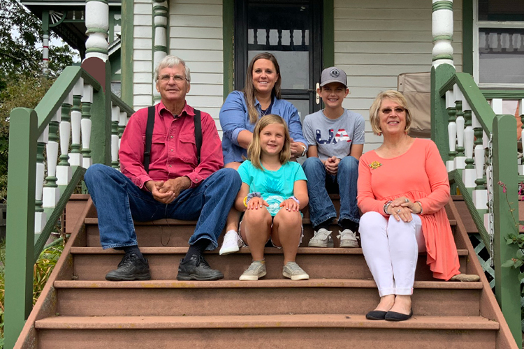Five people sitting on porch steps