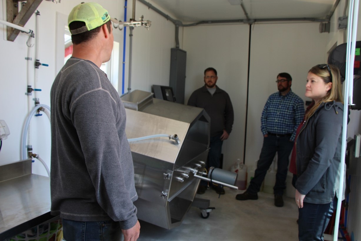 Five People standing in milk bottling room  