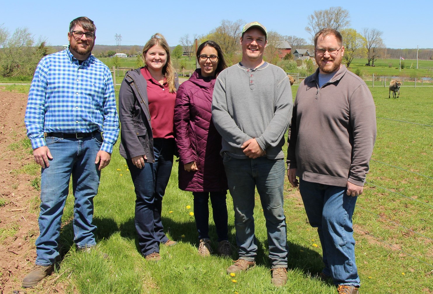 Five people standing in a pasture