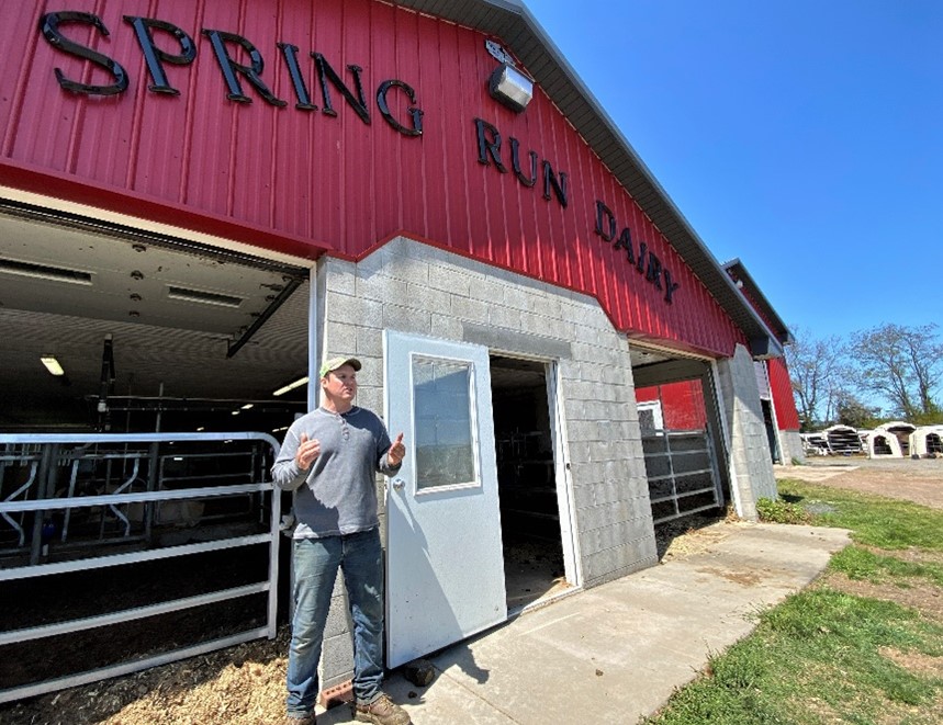 Person stands in front of red barn