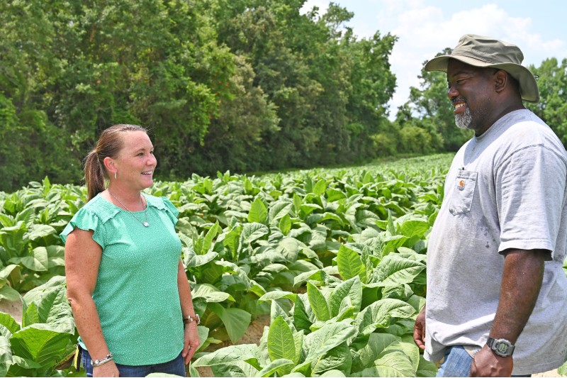 FSA employee talking to customer in a field. 