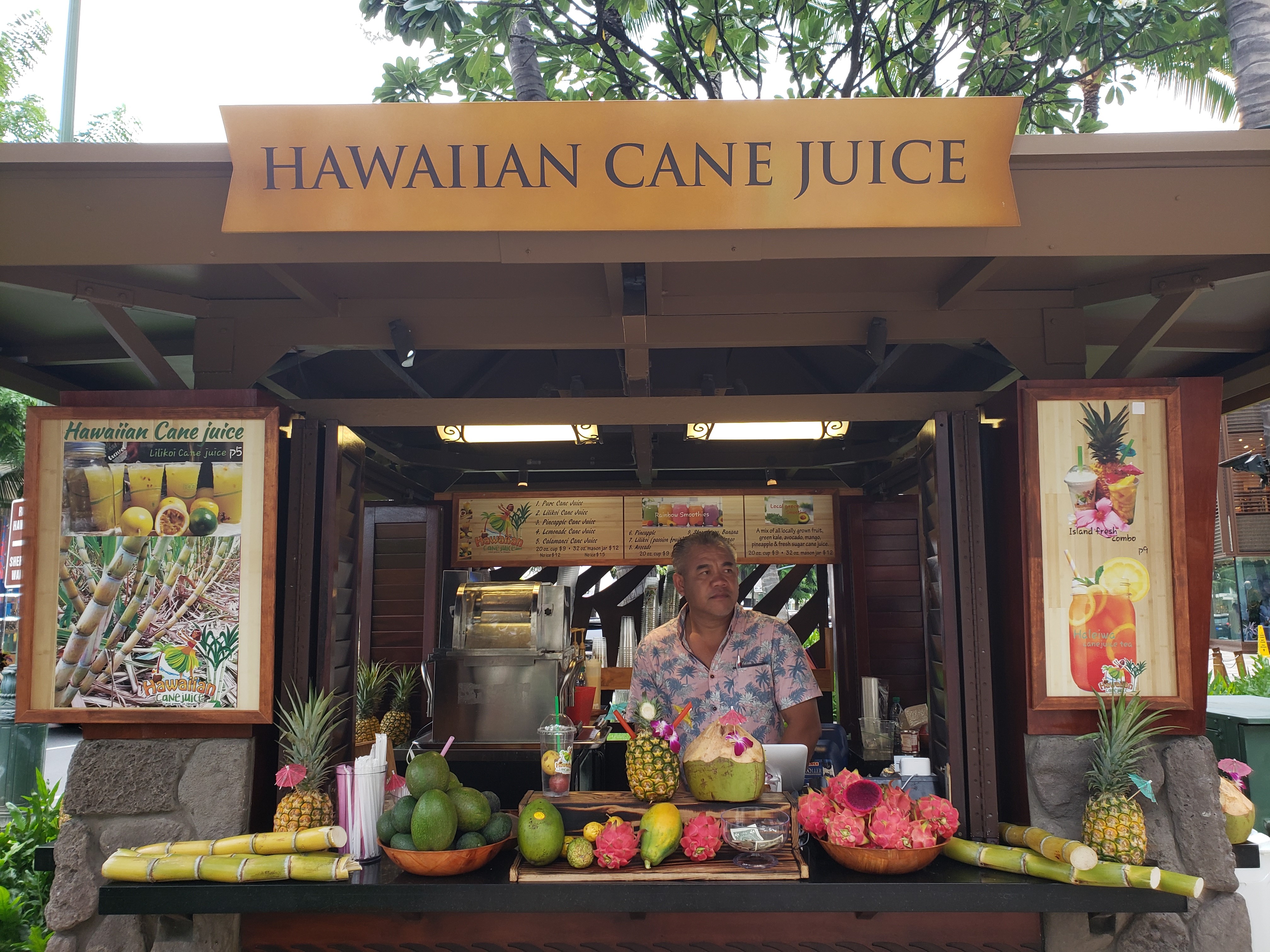 Person standing behind counter of sugar cane stand