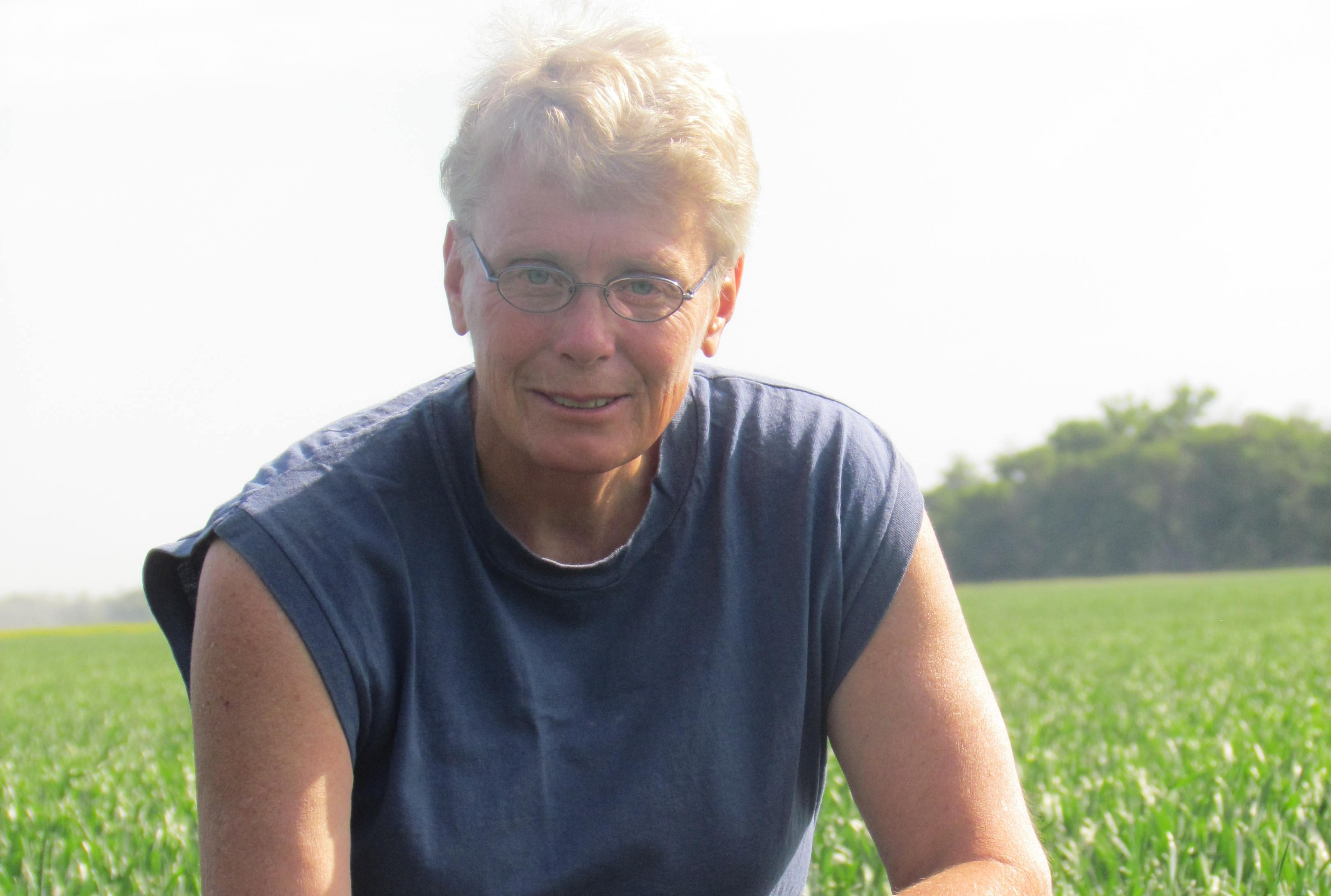 Person sitting in field wearing blue shirt