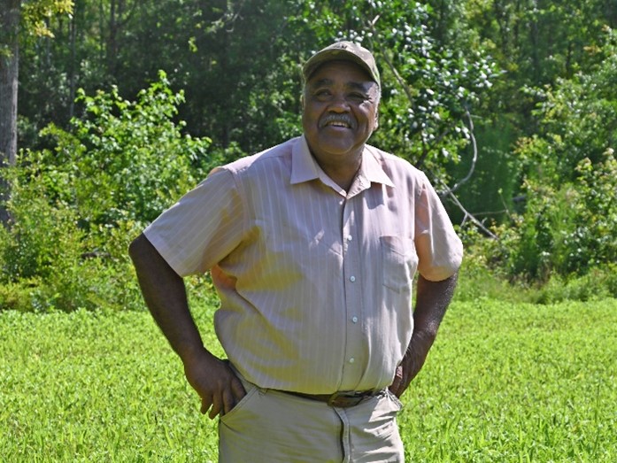 Person standing in grass while smiling