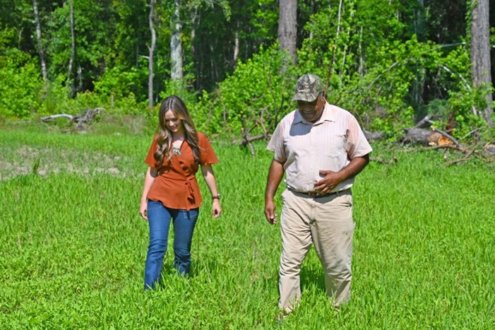 Two people walking on green grass