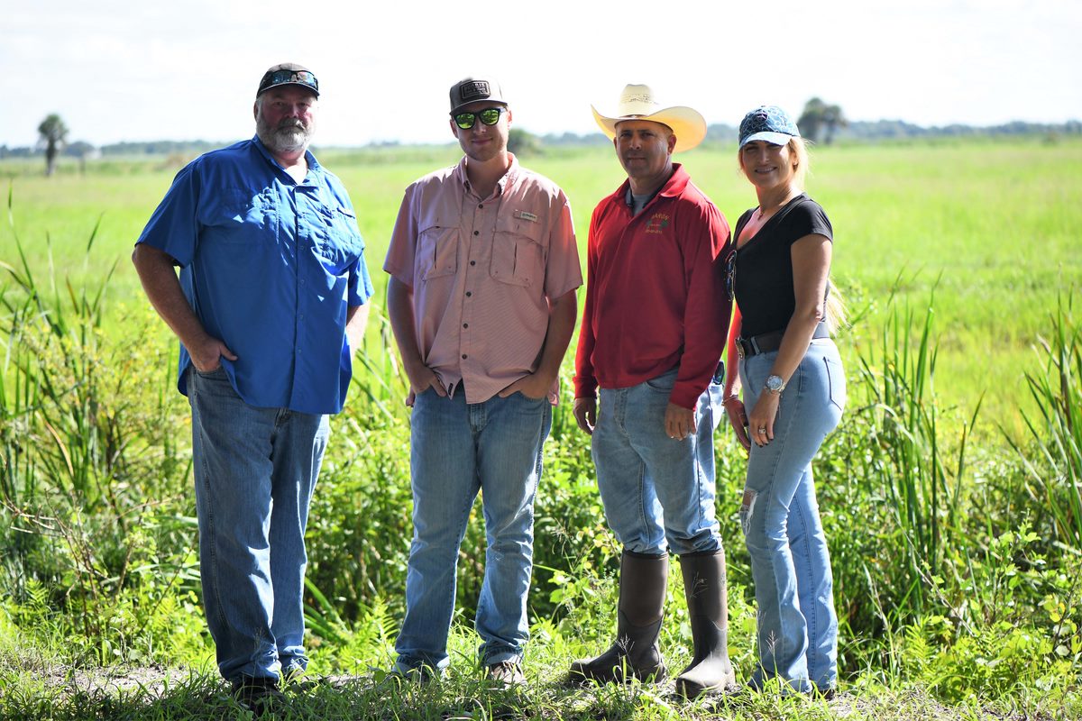 Four people standing in pasture