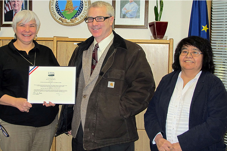 People standing holding and award certificate