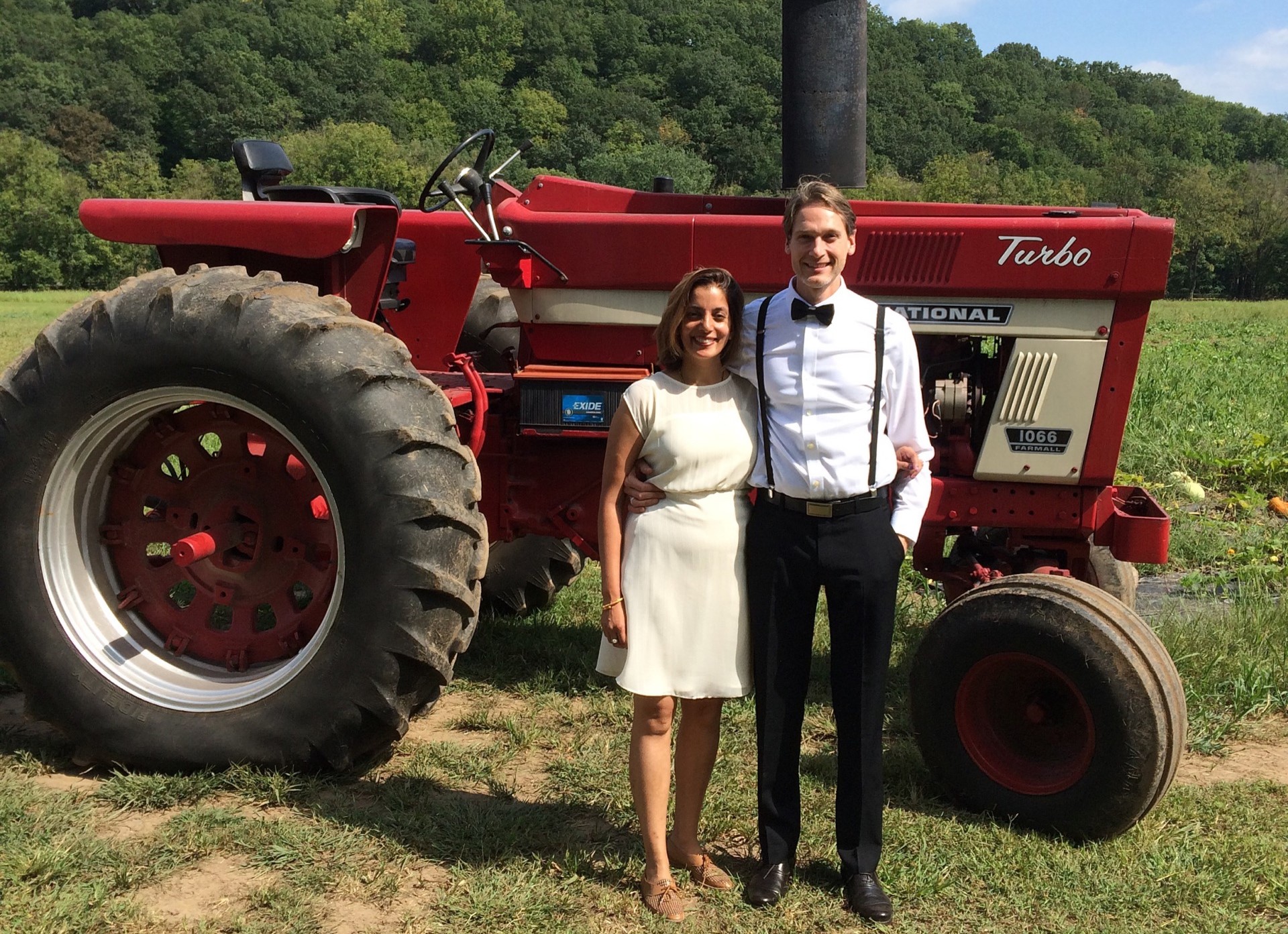 Two people standing in front of red tractor