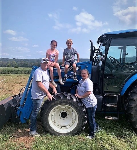 People posing on a green tractor