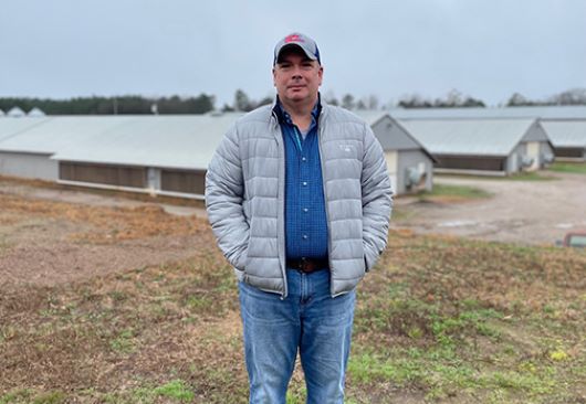 Person standing in front of poultry houses