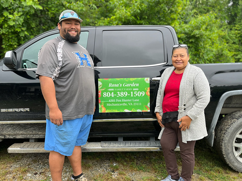 Two people standing in front of a pick-up truck