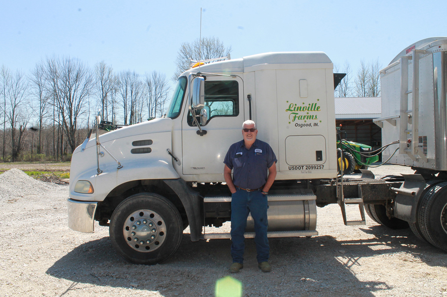 Person standing in front of white 18-wheel truck