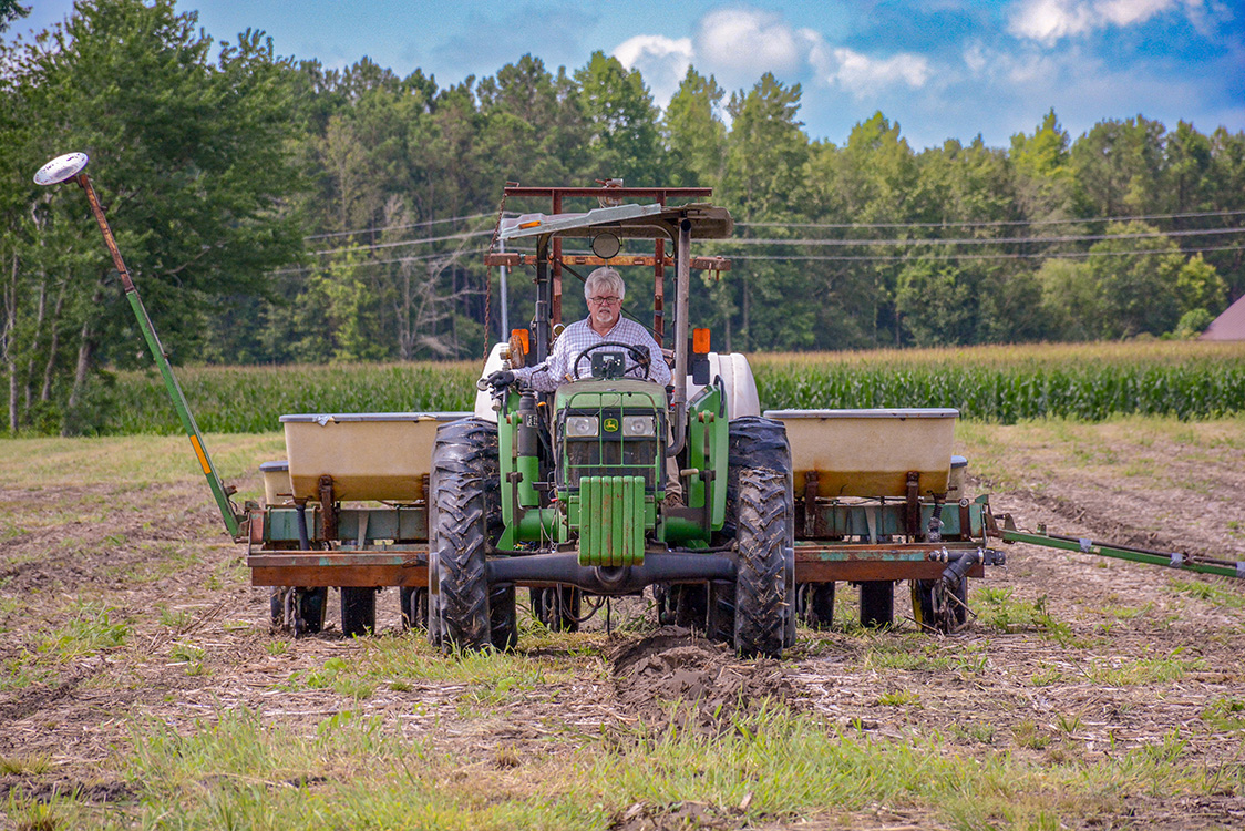 Person in tractor while plowing field