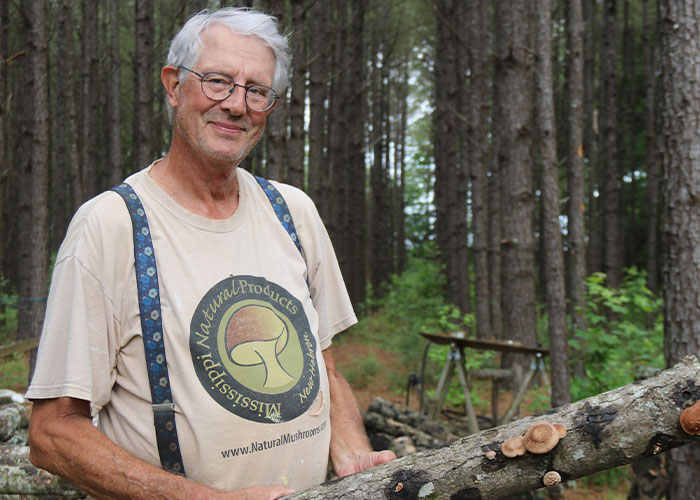 Person holding log with fungi growing on it