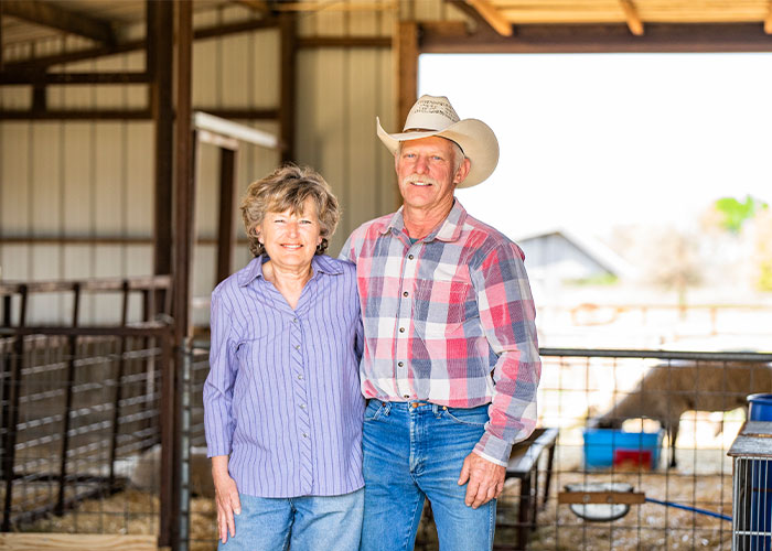 Two people standing in barn