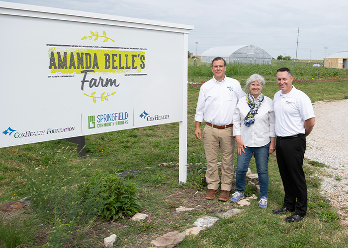 Three people standing in front of sign