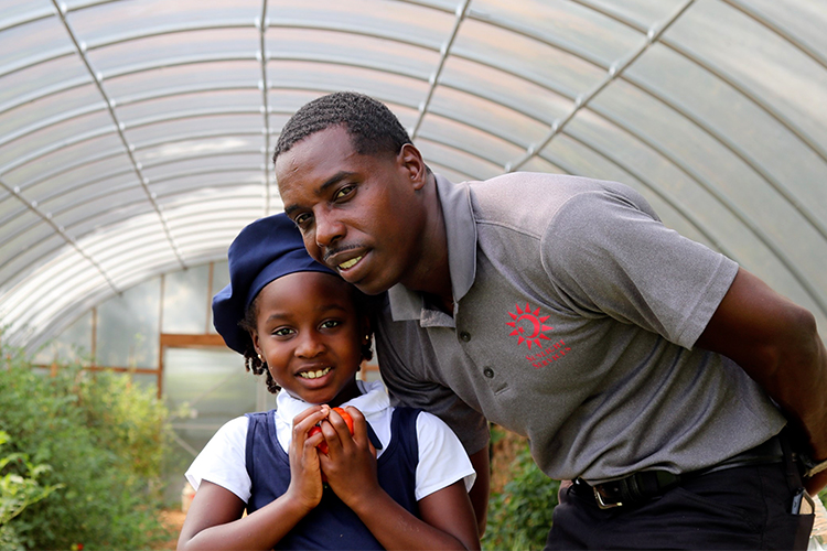 Two people standing in high tunnel