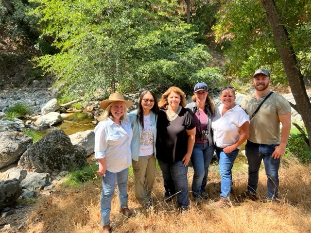 Six people standing by river