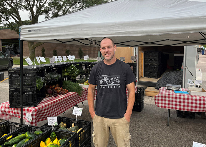 Person standing in front of produce on tables