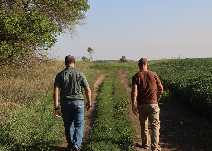 Two people walking down a dirt road