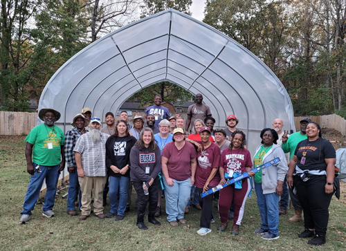 25 people standing in hoop house