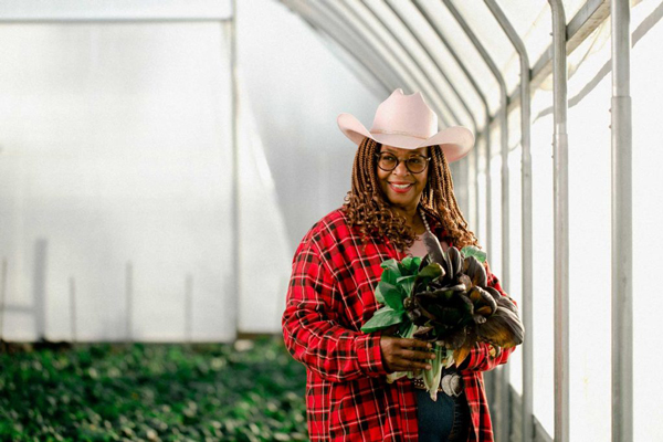 Person holding plant in hoop house