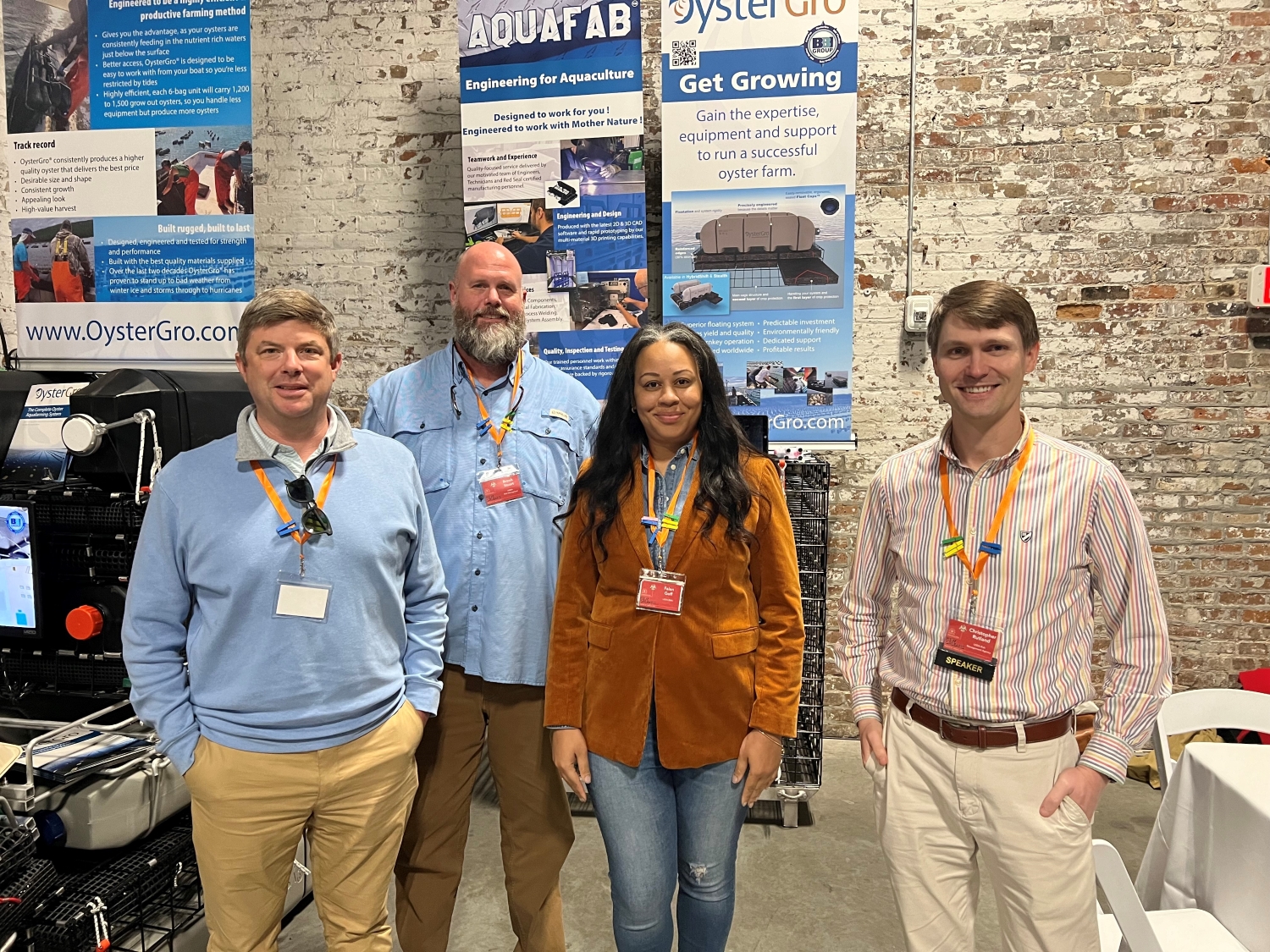 Four people standing in front of oyster banners