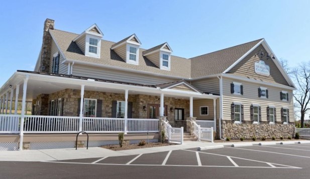 Large Brown House next to a parking lot