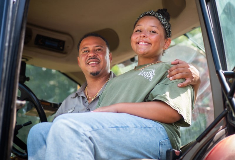 Two people sitting in a tractor's cabin