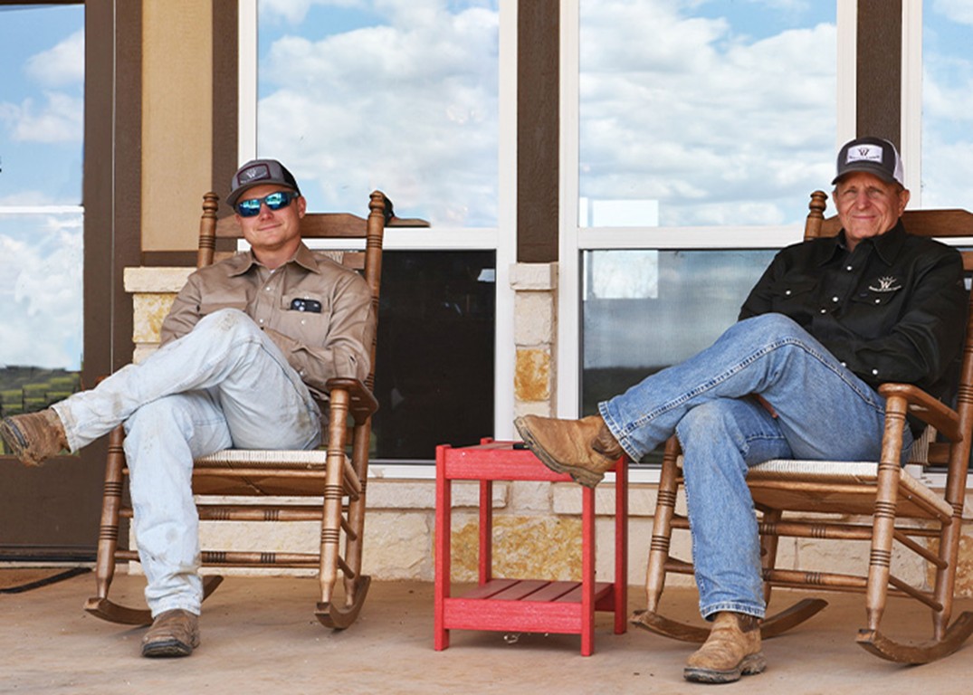 Two people sitting in rocking chairs on a porch