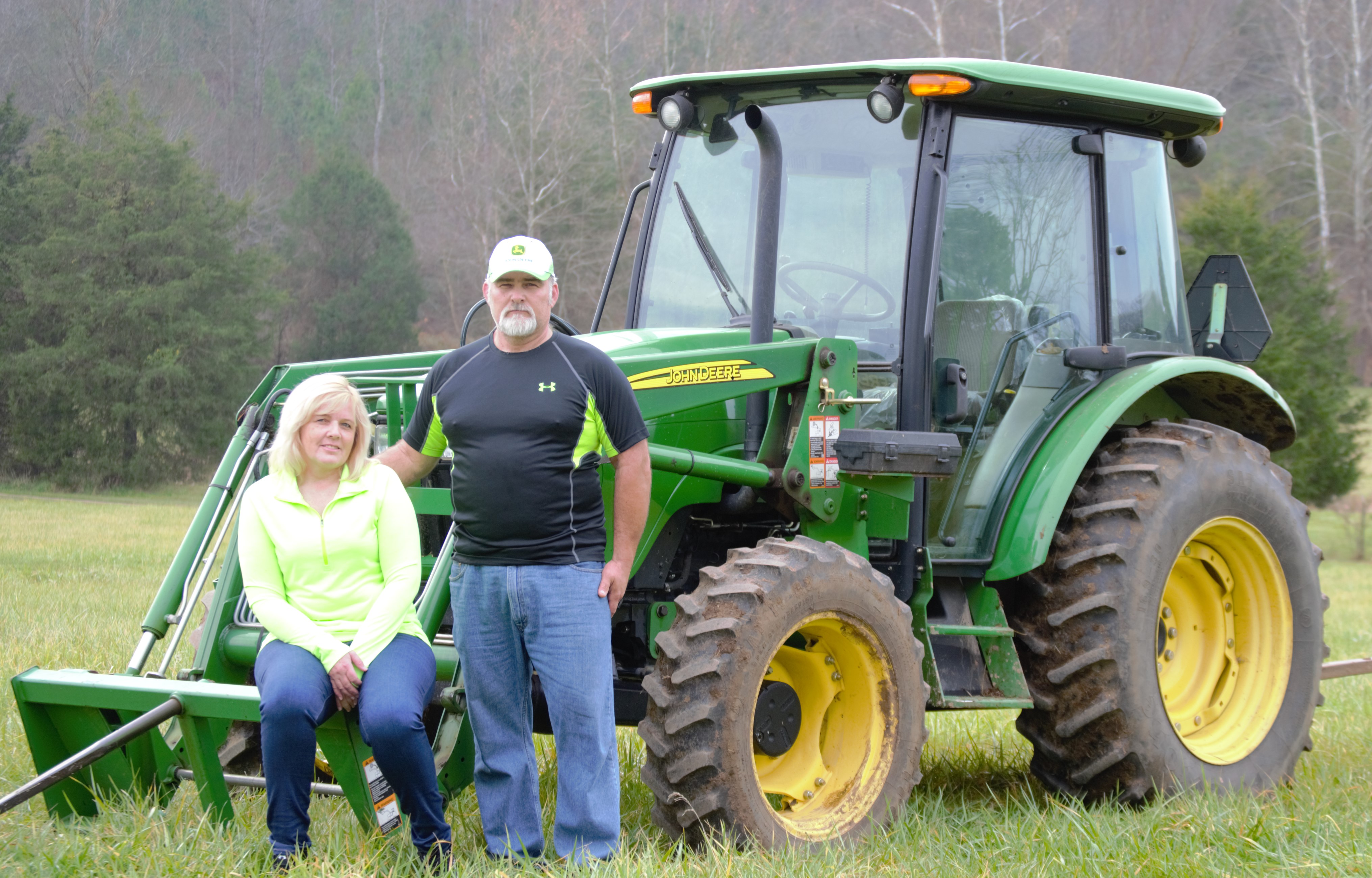 Two people sitting on a green tractor