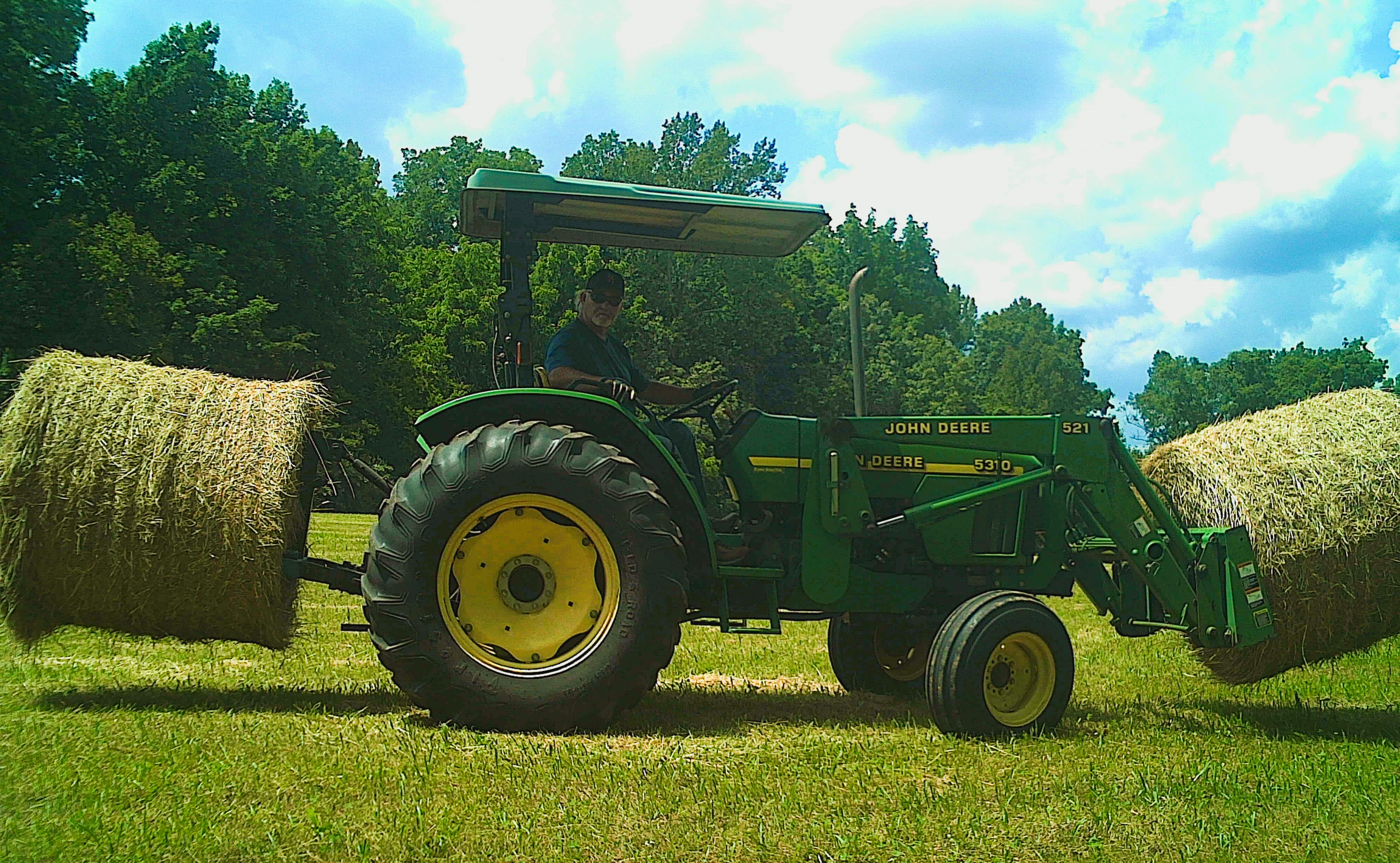 Person driving hay baler tractor