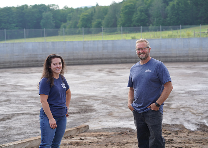 Two people standing in near a river