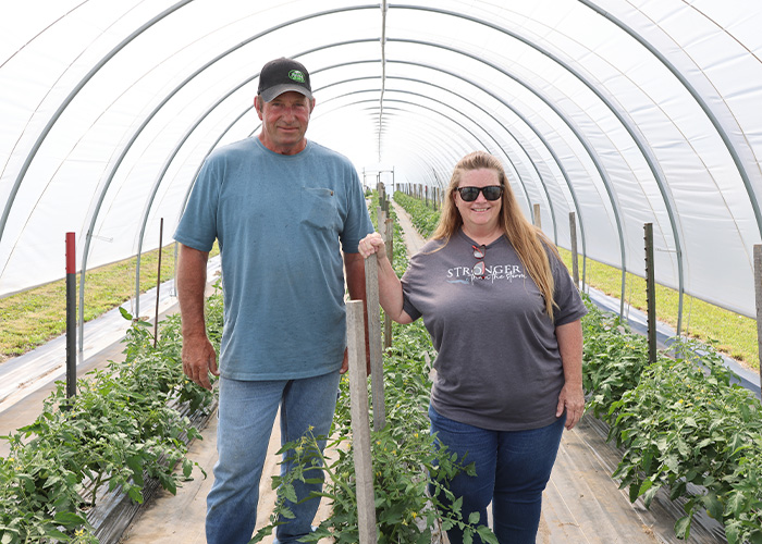 Two people standing in a high tunnel