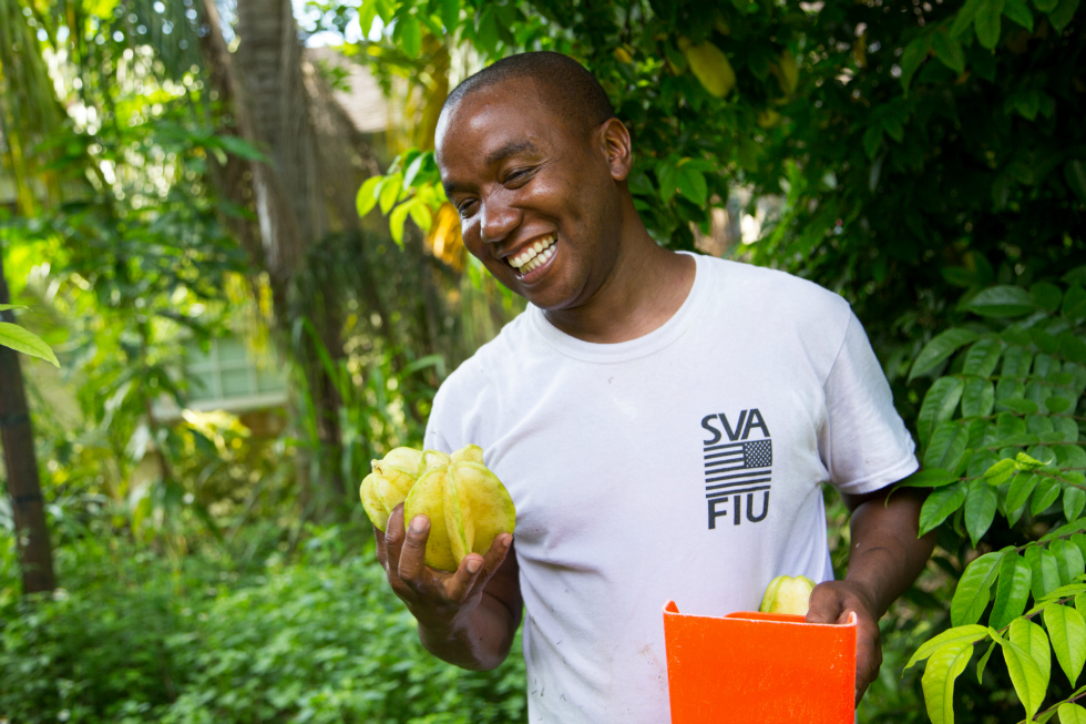 Garfield Jarret, a Marine Corps veteran and the owner and operator of Cool Runnings Organic Farms holds his produce and smiles.  