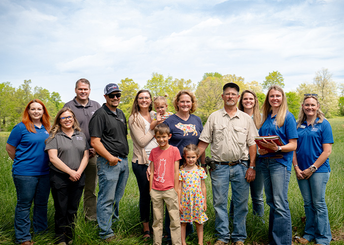 Thirteen people standing in a field