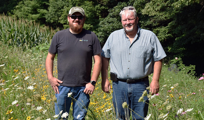 Two people standing amongst flowers