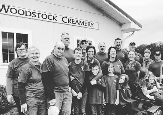 Family photo of the Young family standing in front of the Woodstock Creamery Farm Store at Valleyside Farm.